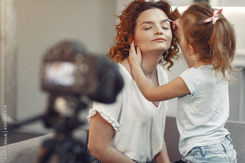 Fototapeta premium Cute little beauty blogger. Girl speaking in front of camera for vlog.