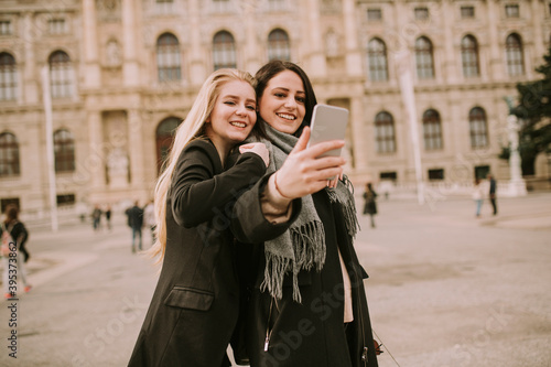 Young female tourists taking selfie with mobile photo in centre of Vienna, Austria © BGStock72