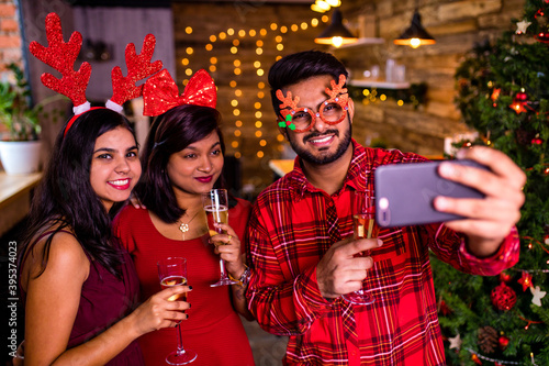 Photography group indian friends cheering with champagne flutes and making selfie photos on