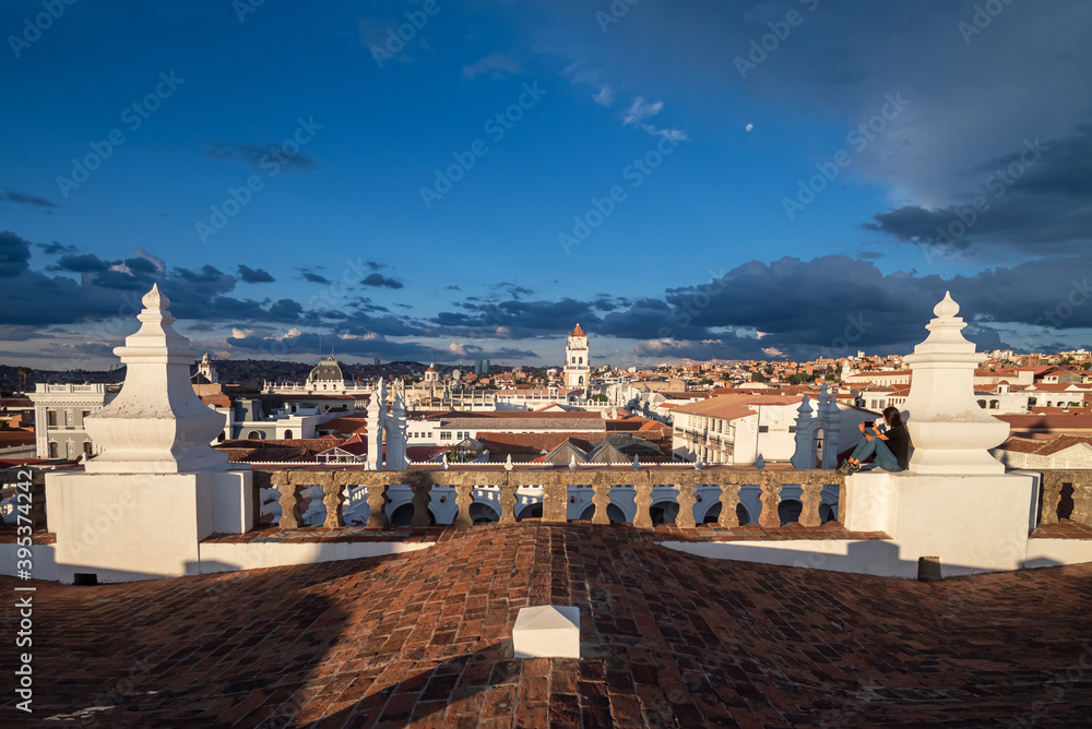 Obraz premium Woman taking pictures of the views over Sucre and its Belltower from a rooftop at Sucre, Bolivia