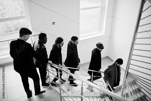 Group of handsome retro well-dressed man gangsters indoor at hotel. Multiethnic male bachelor mafia.