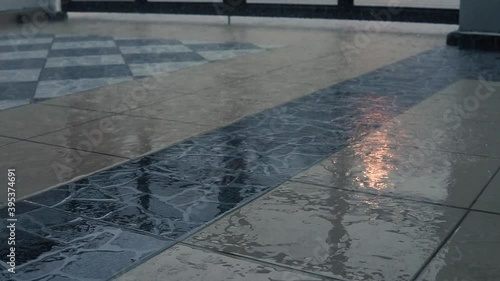 Close up view of heavy rain scene outside of the house. Rain water drop heavily on the floor with street light reflection. Rainy season and bad weather. Selective focus.