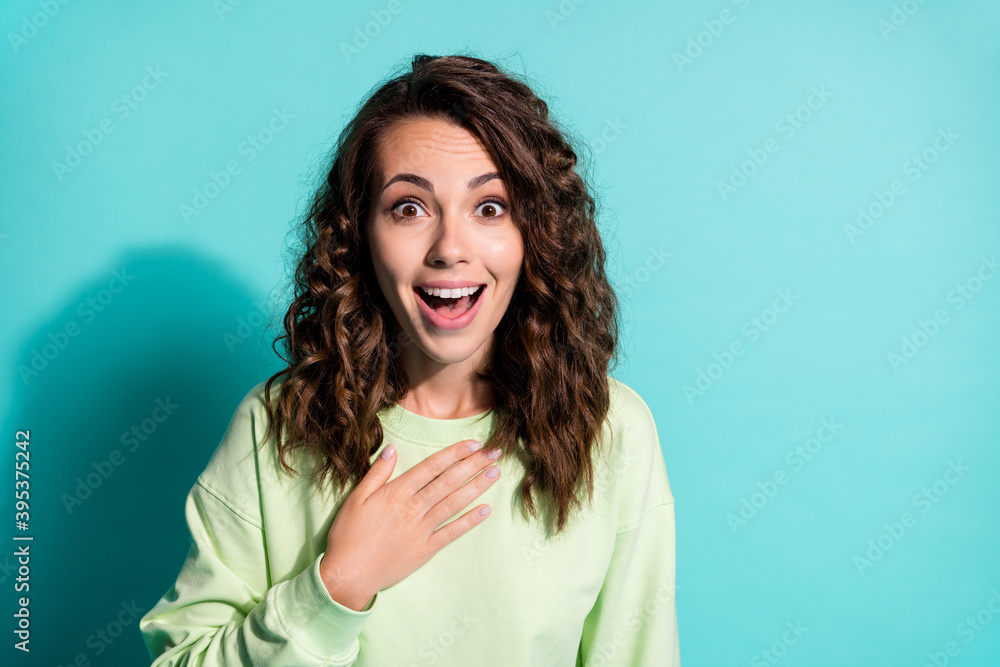 Fototapeta premium Photo of amazed beautiful lady dressed casualwear green pullover hold arm on breast isolated on turquoise color background