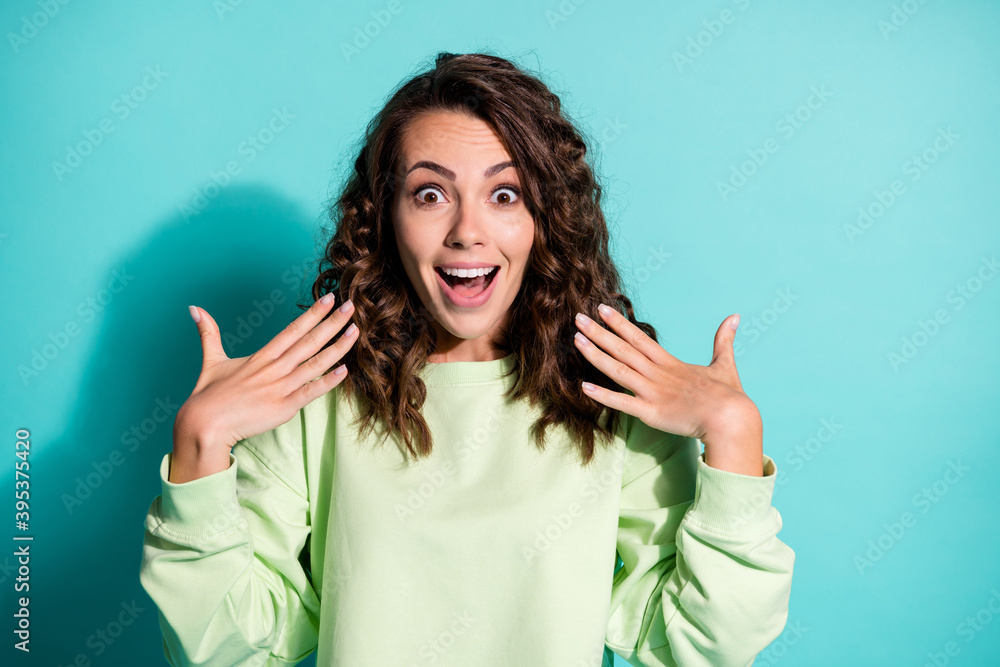 Portrait of astonished young woman dressed casualwear green pullover raise hands isolated on turquoise color background Portrait of astonished young woman dressed casualwear green pullover raise hands isolated on turquoise color background