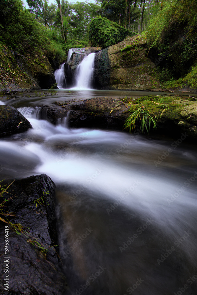 Obraz premium Paradise waterfall in a green forest. Beautiful waterfall in a forest, landscape mode waterfall view.