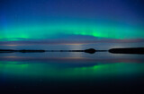 Northern lights dancing over calm lake. Farnebofjarden national park in north of Sweden.