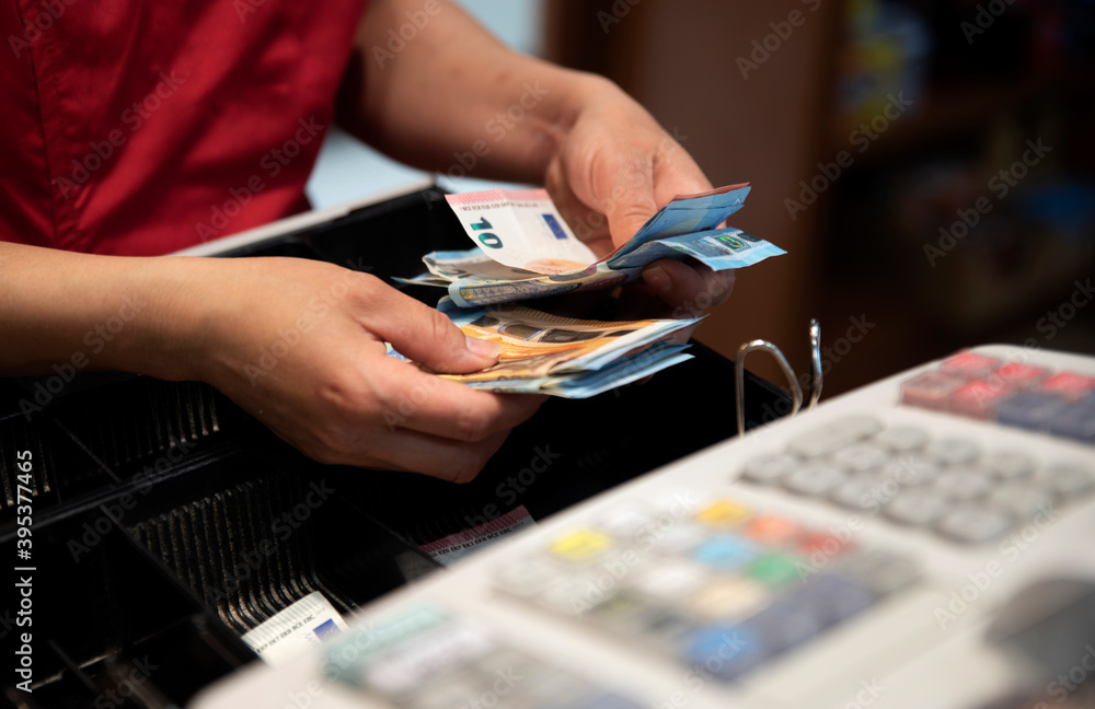 cashier counting the benefits of the day - obrazy, fototapety, plakaty 