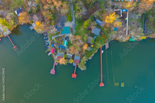 Szigetszentmiklós, Hungary - Aerial drone view of a tiny fishing island on Lake Kavicsos (Kavicsos to) near Budapest. The island is full with fishing huts, piers and cabins. Warm autumn colors. photo