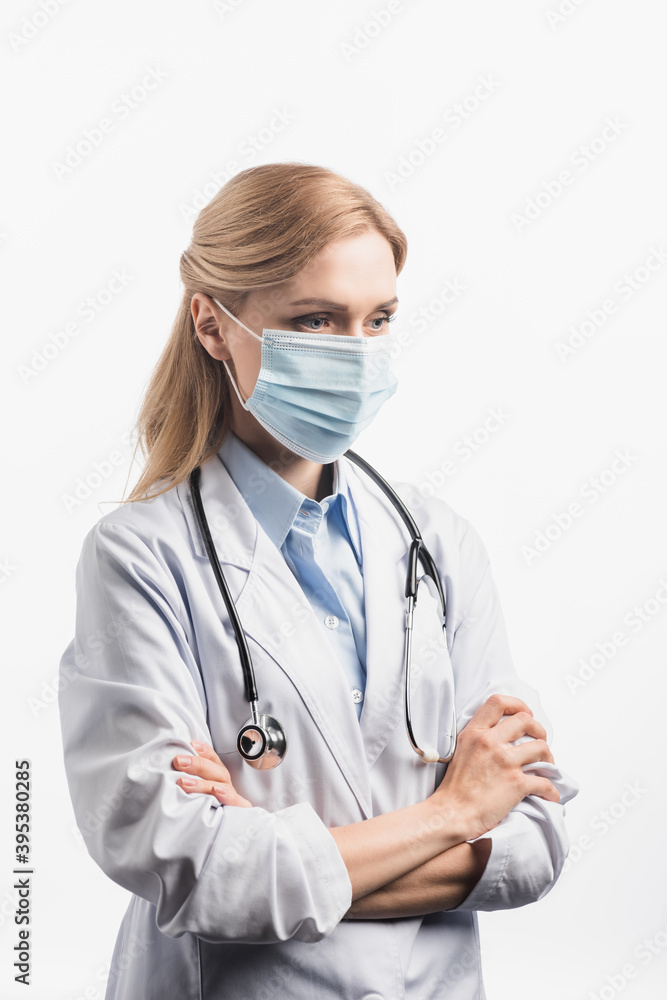 nurse in mask standing with crossed arms isolated on white