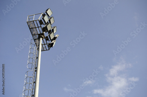 Spotlight pole in stadium and blue sky back ground.