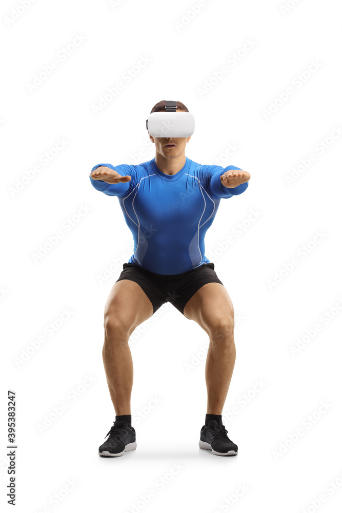 Muscular guy exercising squats with a VR headset