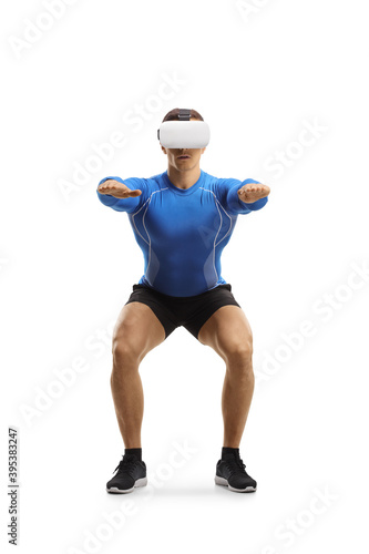 Muscular guy exercising squats with a VR headset © Ljupco Smokovski