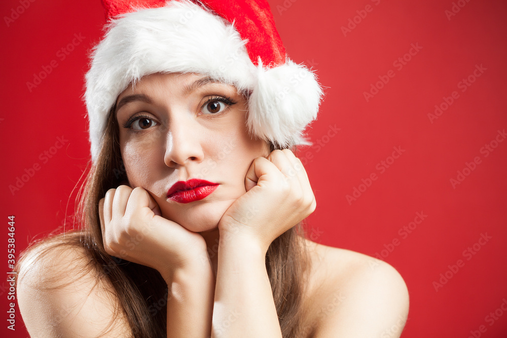 Worried depressed attractive caucasian brunette woman dressed as Mrs Santa Claus,wearing red white hat,chin on hands,isolated on red background,copy space,New Year 2022 COVID-19 Coronavirus pandemic Worried depressed attractive caucasian brunette woman dressed as Mrs Santa Claus,wearing red white hat,chin on hands,isolated on red background,copy space,New Year 2022 COVID-19 Coronavirus pandemic