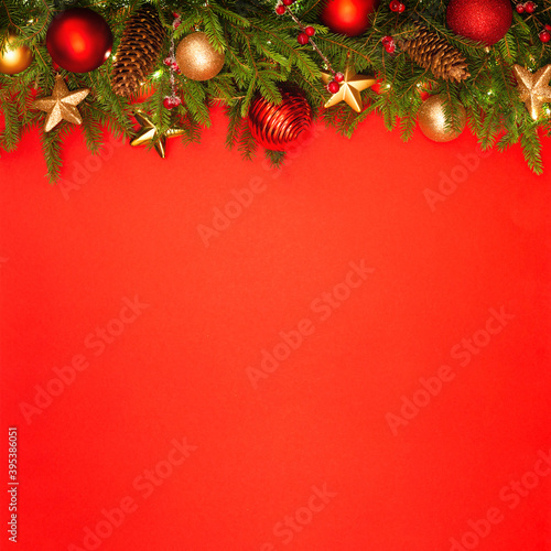 Christmas background with copy space. Festively decorated spruce branches on a red banner. Flat lay style.