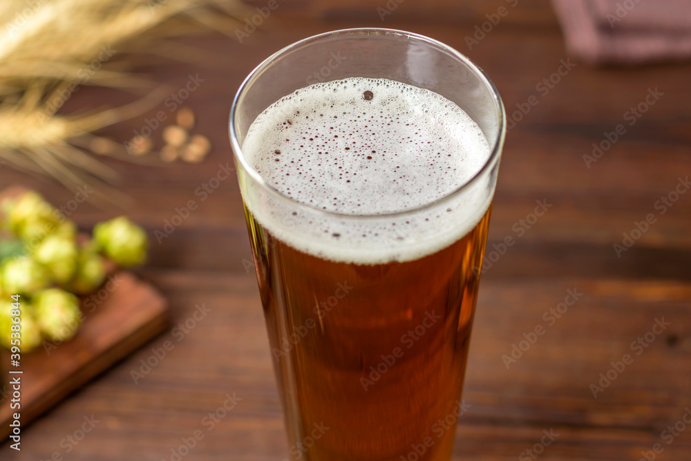 Home brewing concept. Still life with hops, beer and barley on a wooden background. Close-up. Make a lager beer with natural ingredients.