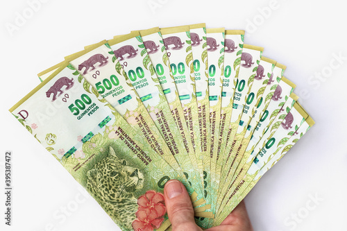 500 Argentine pesos bills offered by female hand in the shape of a fan. 