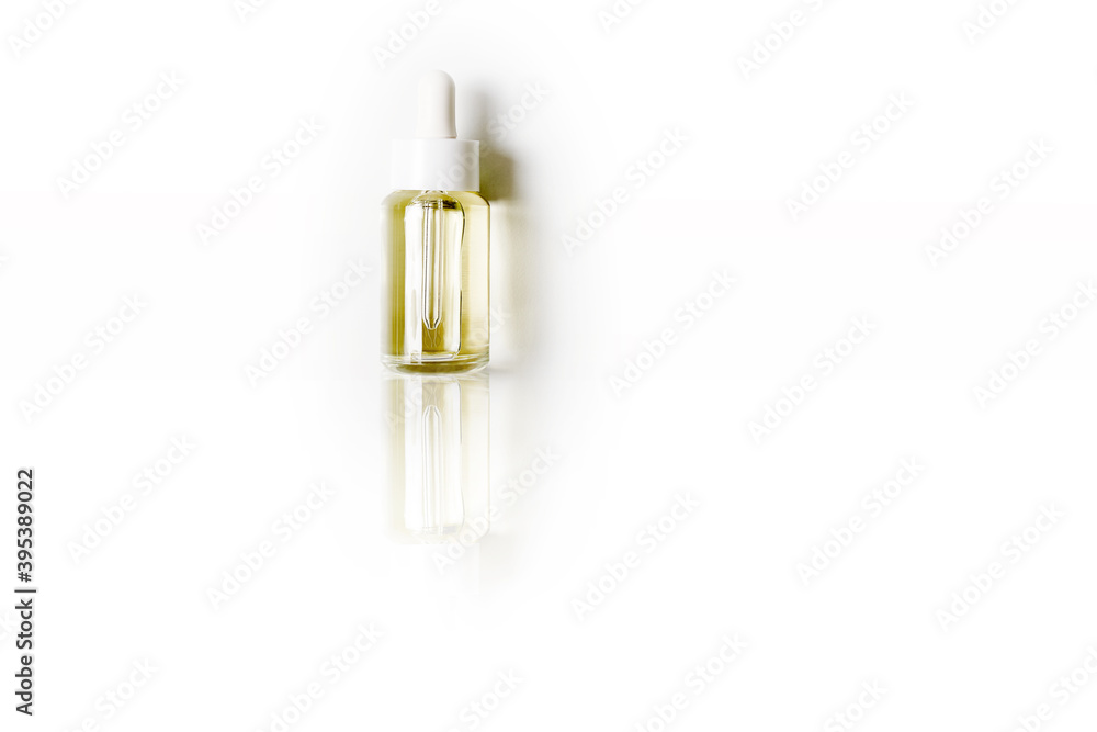 flat lay cosmetic transparent bottle with oil on white mirror background. High quality photo