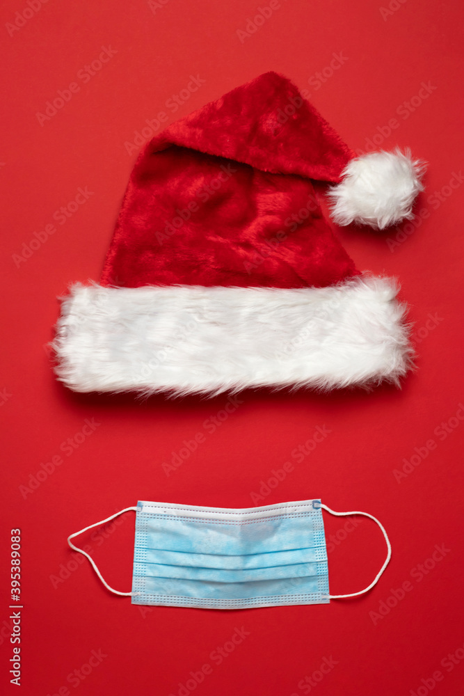 Covid-19 New Year. Red santa claus mask with blue medical mask on red background. Christmas time. Covid-19 New Year. Red santa claus mask with blue medical mask on red background. Christmas time.