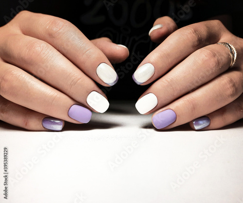 Gentle white-purple gel polish. Women s hands with professional manicure and beautiful design.