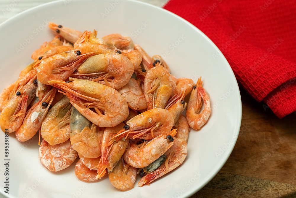 Steamed shrimp on a white plate with seafood sauce in a small bowl. Steamed shrimp on a white plate with seafood sauce in a small bowl.