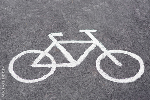 drawn symbol bicycle on asphalt bike path, road sign closeup on the ground.