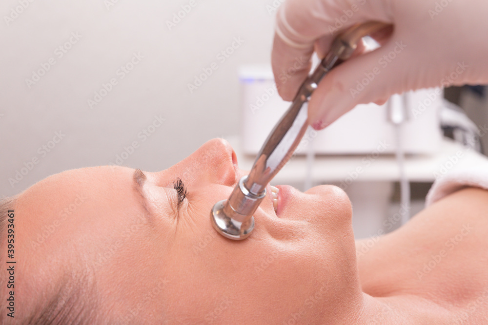 Fototapeta premium The cosmetologist makes the procedure Microdermabrasion of the facial skin