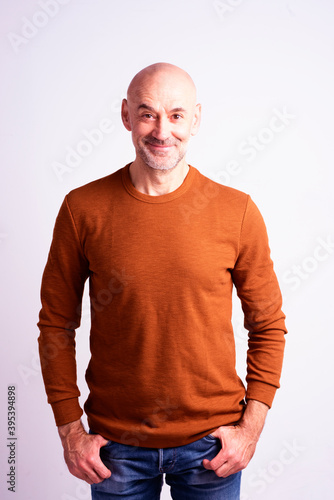 Happy middle aged man portrait while standing at isolated white background