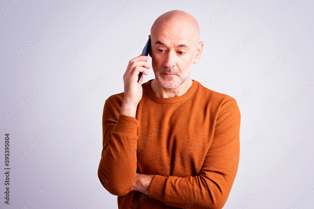 Man using mobile phone and wondering while standing against at isolated grey background Man using mobile phone and wondering while standing against at isolated grey background
