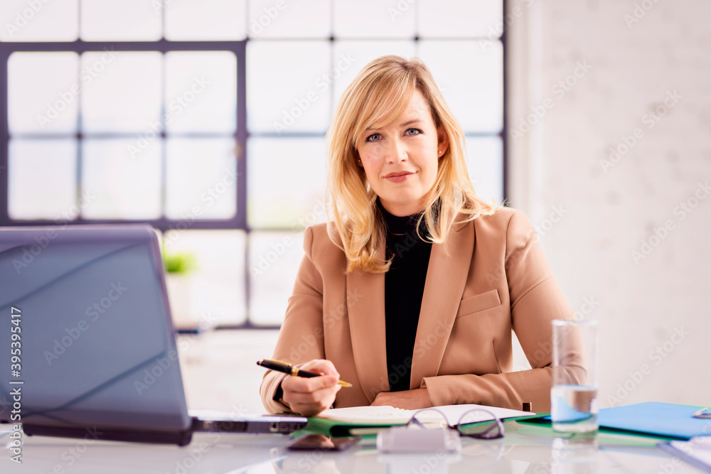 Businesswoman working on laptop while sitting at desk Businesswoman working on laptop while sitting at desk
