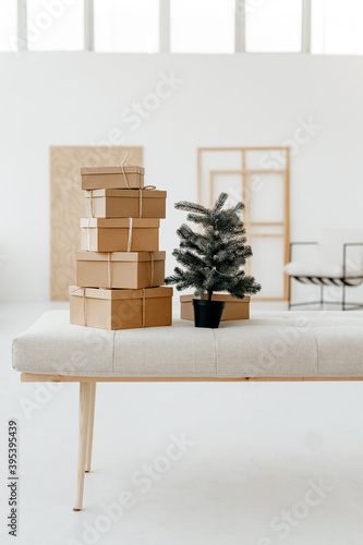 Christmas and new year gift boxes made of craft paper on a white wall background.