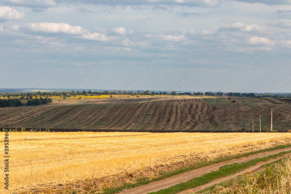 autumn landscape with harvested and plowed fields and clouds