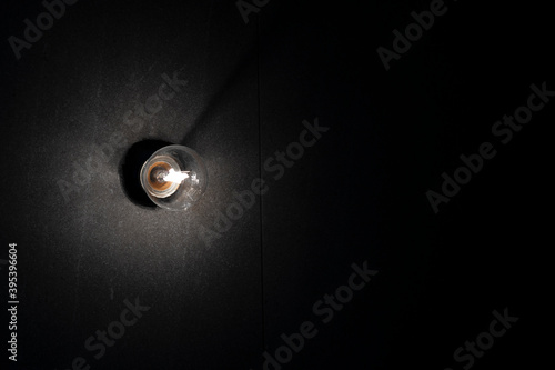 Background image of dark wall with lamp above.