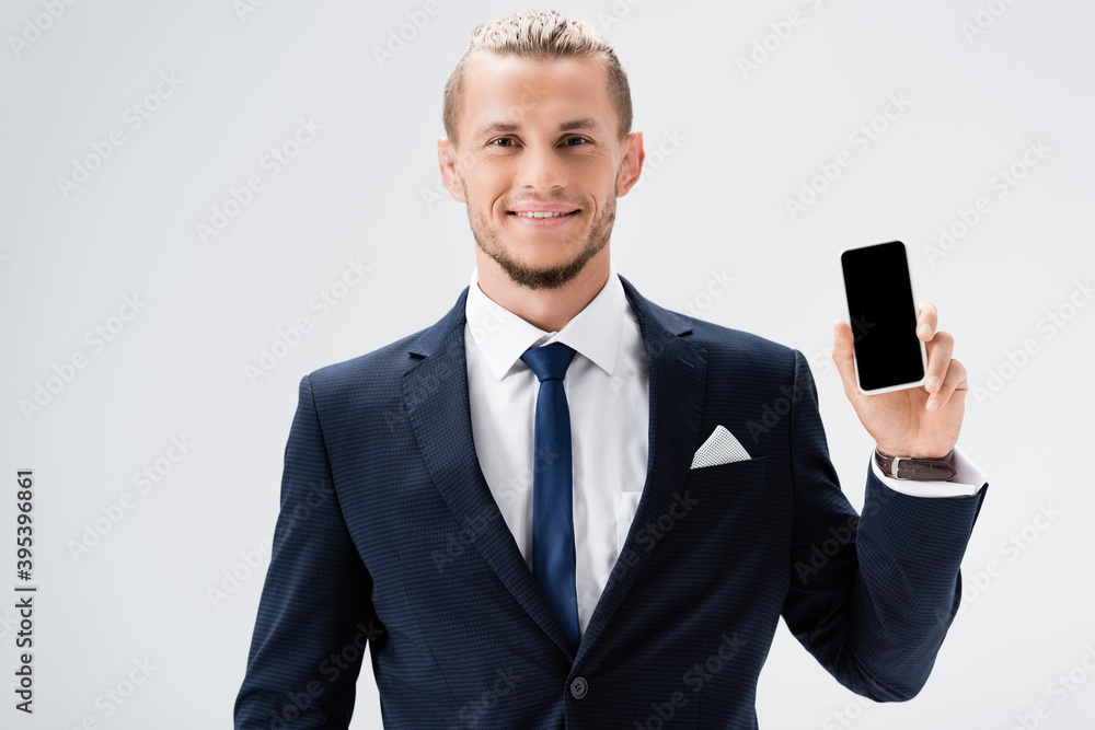 young businessman in suit presenting smartphone isolated on white young businessman in suit presenting smartphone isolated on white