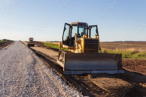 Bulldozer during road construction. Construction machinery. Earth moving by a bulldozer in the construction of a road. Excavator on a construction site of a road