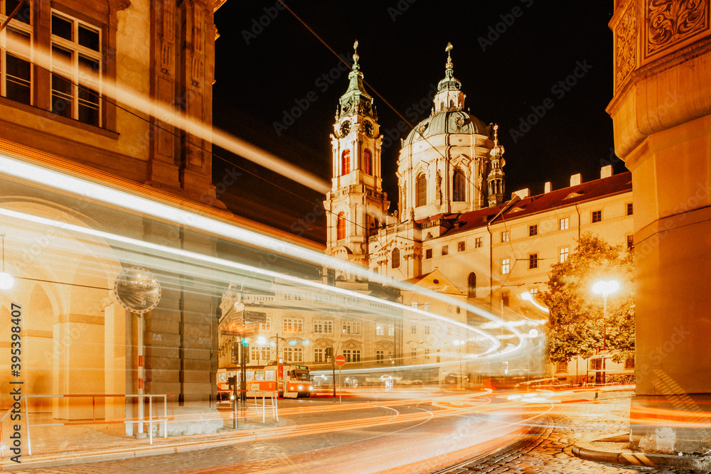 Night view of St. Nicolas Church, Prague, Czech republic. Long exposure city lights.Motion speed scene.Traffic trails in town.City street at night.Transportation travel background.Urban development.