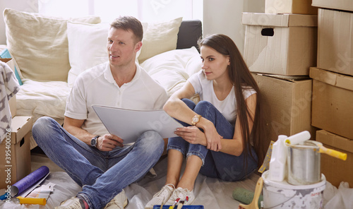 Young Hispanic couple looking at blueprints of new home  high angle view