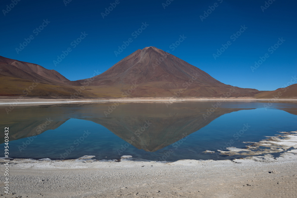 Reflections of mountains in the clear water of the Green Lake (Laguna Verde) on the Bolivian altiplano, Bolivia