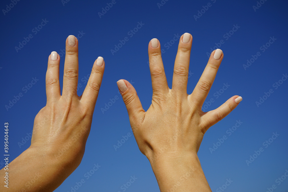 women's hands show the number eight against a cloudless blue sky women's hands show the number eight against a cloudless blue sky