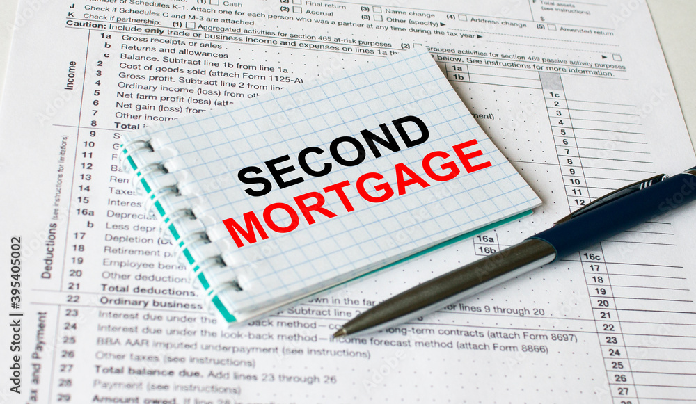 Notepad with text Second Mortgage lying on financial tables with a pen Notepad with text Second Mortgage lying on financial tables with a pen
