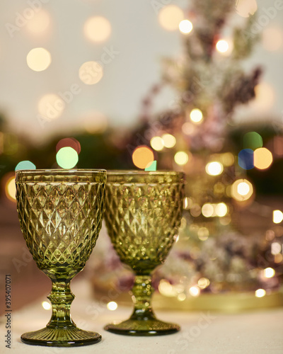 two green glasses on a wooden table. Christmas decorations