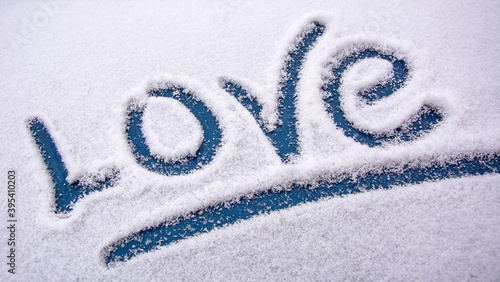 Love in the snow. The word love is drawn with your finger on the snow surface. Declaration of love. Sign of attention.