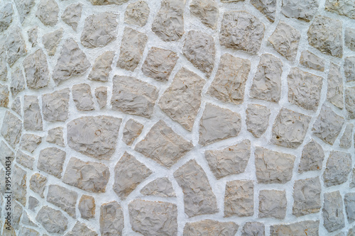 Grey rock material wall from exterior of a traditional house. Typical contruction structure made of stone. 