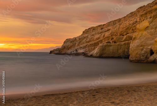 Sunset next to the roman catacombs carved on the sandstone cliffs above the Matala Beach, Crete, Greece. In Roman times, the dead were buried in them, later they were used by the first Christians