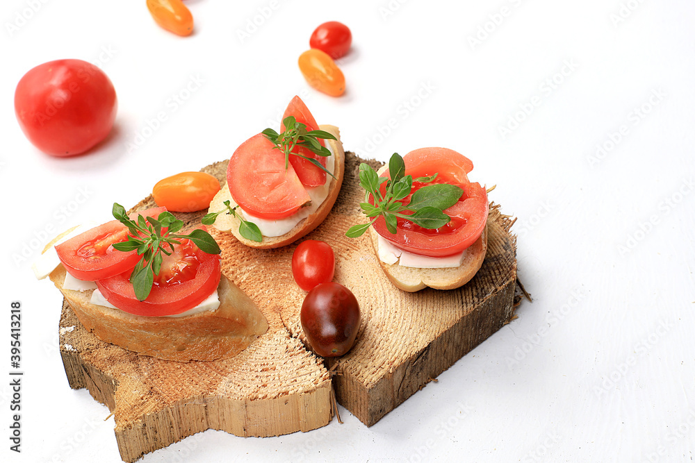 Caprese and Toast bruschetta with mozzarella cheese, cherry tomatoes and fresh garden basil. Traditional Italian food, healthy natural breakfast, cholesterol and GMO free, space for text,