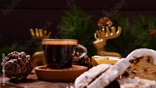 Traditional German sweet bread for Christmas. Stollen and aromatic espresso coffee with gift boxes on a wooden background. 