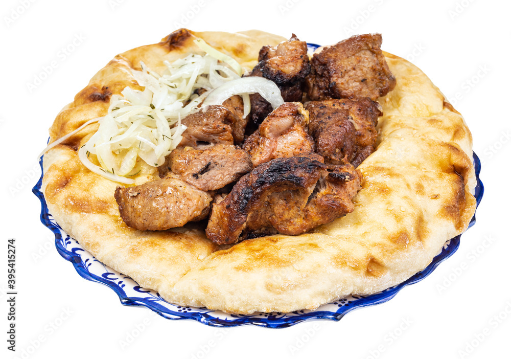portion of kebab on flatbread on plate isolated on white background portion of kebab on flatbread on plate isolated on white background