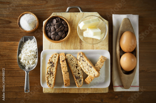 Tozzetti or cantuccini, homemade Italian biscuits with flour, chocolate, butter, eggs and sugar. Top view on wooden background. photo