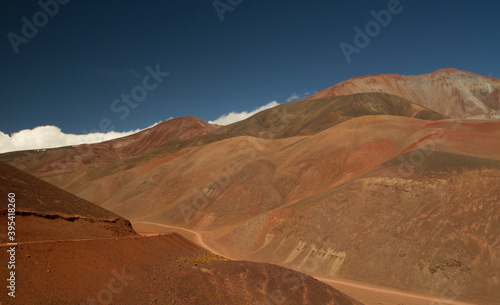 Traveling the extreme dirt road across the Andes mountain range. View of the brown mountains, precipice, dunes and route high in the cordillera, driving towards Laguna Brava in La Rioja, Argentina. © Gonzalo