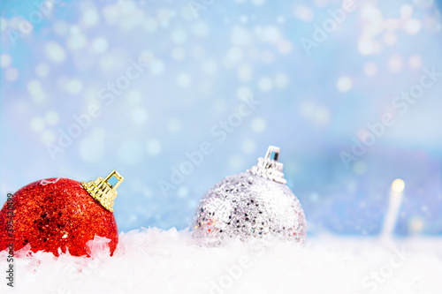 Close-up of bright red and silver Christmas decorations buried in snow (ID: 395420499)