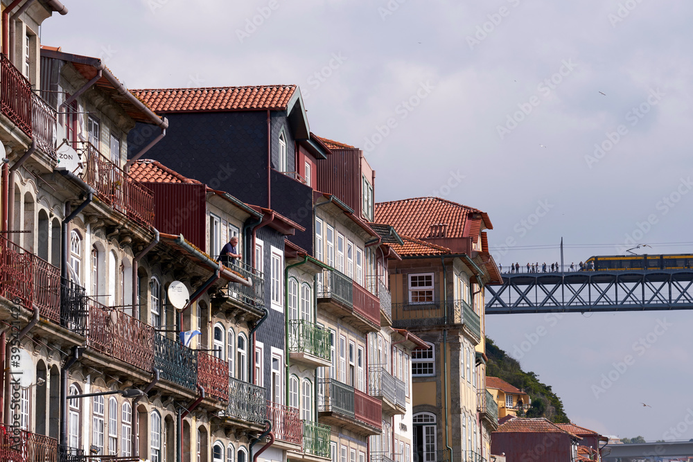 Man on balcony in front of historic house facade in the old town of Porto